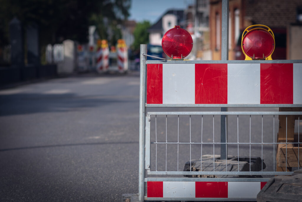 Eine Absperrung an einer Baustelle nah fotografiert, Hintergrund ist verschwommen