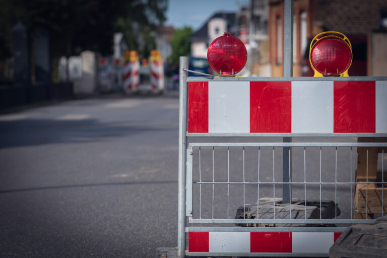 Eine Absperrung an einer Baustelle nah fotografiert, Hintergrund ist verschwommen