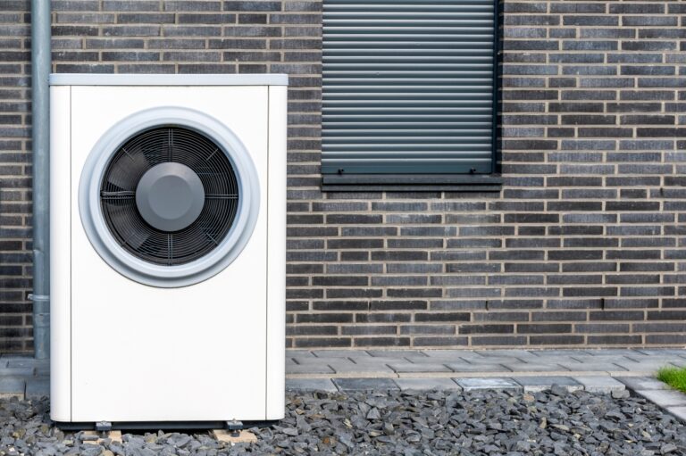 Wärmepumpe steht vor Backsteinwand